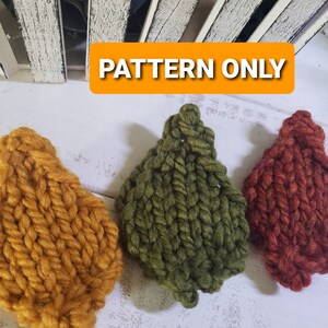 Puede incluir: Tres hojas tejidas en colores otoñales: dorado, verde oliva y rojo óxido. Las hojas están dispuestas sobre una superficie blanca, con una estructura de madera blanca desgastada en el fondo. El texto "PATTERN ONLY" se muestra en un rectángulo naranja.