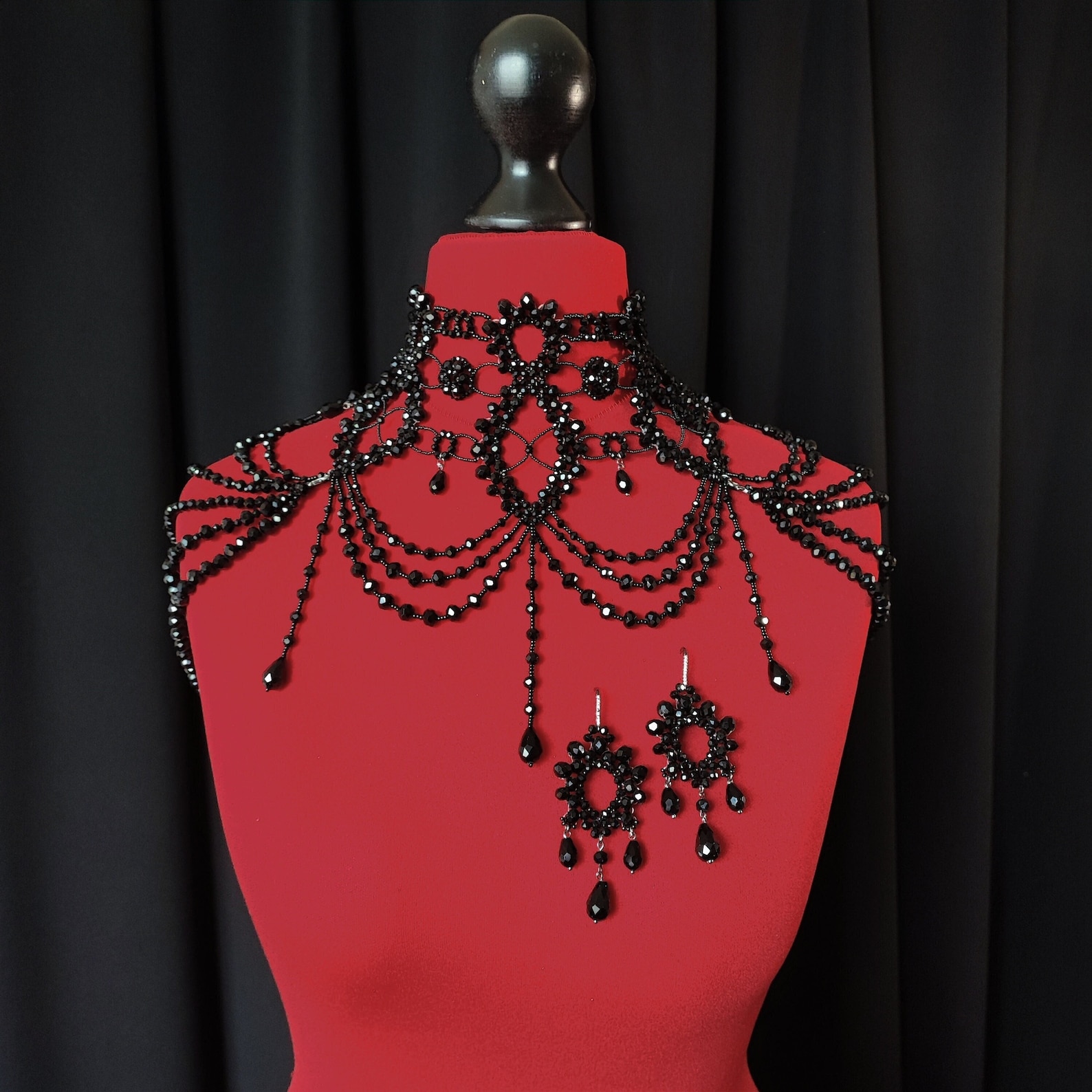 Black beaded gothic necklace with Victorian-inspired crystal festoon draping on red mannequin bust.
