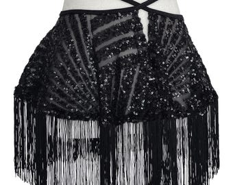 May include: A black skirt featuring a sheer mesh base adorned with dense, sparkling black sequins arranged in a fan-like pattern. The garment includes a high-waisted design with thin, crisscrossing black straps and a long, flowing fringe hemline.