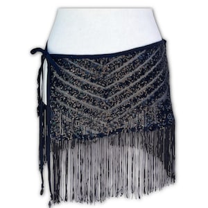 May include: A navy blue wrap skirt with a sequined chevron pattern. The skirt features long fringe along the bottom edge and tie closures. The skirt is designed for dance or costume use.