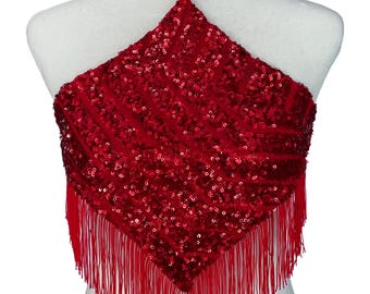 May include: A bright red halter top covered in dense, shimmering sequins arranged in a diagonal striped pattern. The garment features a pointed hemline adorned with long, thin red fringe that hangs from the bottom edges, and a thin neck strap.