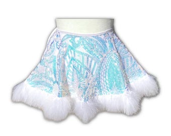 May include: A white, sequined skirt with a turquoise and white pattern. The skirt has a white waistband and is trimmed with fluffy white feathers along the hemline. The skirt is designed to be worn around the waist.