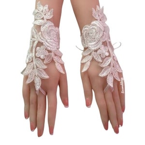 May include: A pair of white lace fingerless gloves with floral embroidery. The gloves have a delicate design with a large rose and leaves.