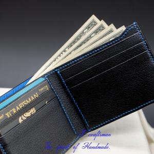 May include: A black leather wallet with blue stitching, open to reveal cash and a credit card with the text "X CRAFTSMAN".