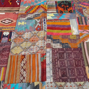 May include: A patchwork rug made of various colorful fabrics with geometric patterns. The rug is made up of many different squares and rectangles, each with a unique design. The colors are vibrant and bold, and the overall effect is one of intricate detail and craftsmanship.