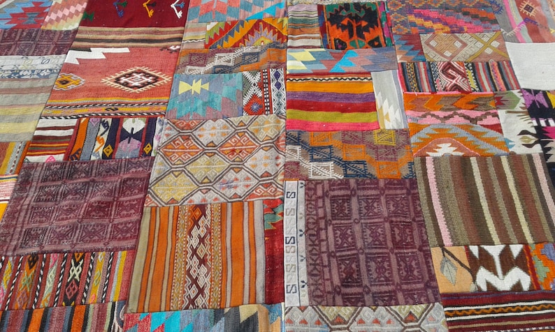May include: A patchwork rug made of various colorful fabrics with geometric patterns. The rug is made up of many different squares and rectangles, each with a unique design. The colors are vibrant and bold, and the overall effect is one of intricate detail and craftsmanship.