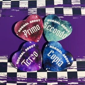 May include: Four heart-shaped pins with a watercolor background. Each pin has the text "Normal About" and a number in old English font. The numbers are "Primo", "Secondo", "Terzo", and "Copia".