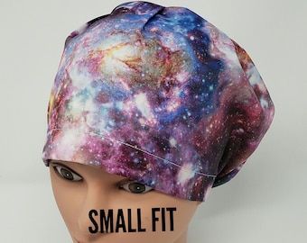 Könnte beinhalten: Eine OP-Haube mit Galaxiedruck und kleiner Passform. Die Haube hat ein lebendiges Design aus wirbelnden Blau-, Lila- und Rosatönen, das einem Nebel ähnelt. Der Text "SMALL FIT" ist auf der Vorderseite aufgedruckt.