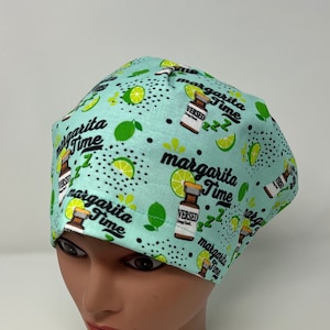 May include: A light teal surgical scrub cap with a repeating pattern of lime slices, tequila bottles, and the words "Margarita Time." The cap is designed to cover the head and hair, commonly used in medical settings.