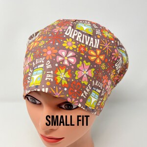 May include: A brown scrub hat with a colourful floral pattern and the text "Take a Ride on the Diprivan" in a retro font. The hat is on a mannequin head and says "Small Fit" below the hat.