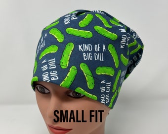 Könnte beinhalten: Eine marineblaue OP-Haube mit einem sich wiederholenden Muster aus grünen Gurken und dem Text "KIND OF A BIG DILL". Die Kappe ist mit "SMALL FIT" beschriftet. Die Kappe ist zum Tragen auf dem Kopf bestimmt.