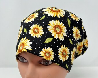 Könnte beinhalten: Schwarze OP-Mütze mit Sonnenblumenmuster und weißen Punkten.