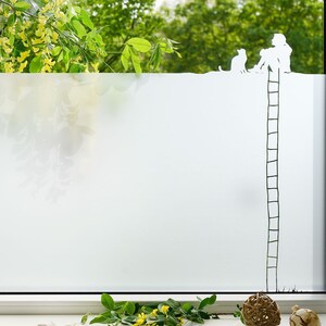 Könnte beinhalten: Ein Fenster mit einer Milchglasfolie, die eine Silhouette einer Person, einer Katze und einer Leiter zeigt. Die Person und die Katze befinden sich auf einem Sims. Grünes Laub ist draußen zu sehen. Dekorative Gegenstände sind auf der Fensterbank.