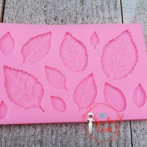 May include: Pink silicone mold with 11 leaf shapes, perfect for making fondant or gum paste decorations.  The mold features a variety of leaf sizes and shapes.