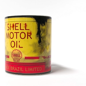 May include: A yellow and red ceramic mug with a vintage Shell Motor Oil can design. The mug has black dripping oil and the text "Shell Motor Oil" and "Mex Brazil Limited".