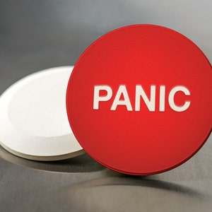 May include: A red round button with the word "PANIC" in white lettering. The button is next to a white round button.