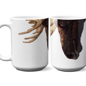 May include: White ceramic coffee mug with a brown and white moose illustration. The moose's head is on the right side of the mug and its antlers are on the left side of the mug.