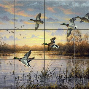 May include: A decorative wall tile mural featuring a painted landscape of a marsh at sunset with several mallard ducks in flight. The scene includes tall grasses in the foreground, calm water reflecting the sky, and the signature of Abraham Hunter.