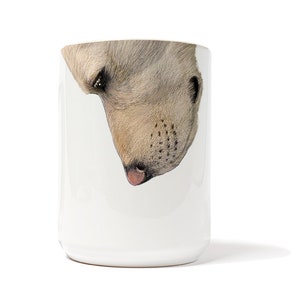 May include: White ceramic mug featuring a close-up image of a polar bear's face. The bear's nose is pink and its eyes are black.