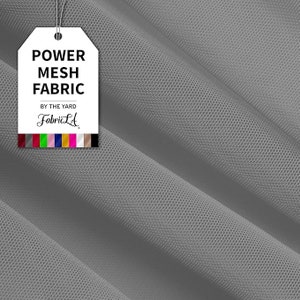 May include: A close-up of gray power mesh fabric with a tag that reads "POWER MESH FABRIC" and "BY THE YARD" with the FabricLA logo. The fabric is folded, showing the texture and weave. A color palette is at the bottom of the tag.