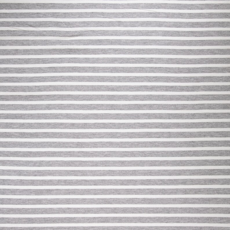 May include: A close-up of a fabric with horizontal stripes. The stripes alternate between light gray and white, creating a simple, yet visually appealing pattern. The fabric appears to be soft and likely used for clothing or home decor.