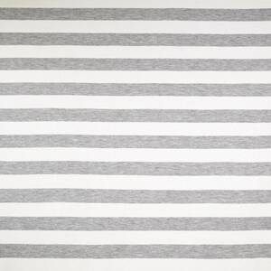 May include: A close-up shot of a fabric with a repeating pattern of horizontal stripes. The stripes alternate between wide bands of white and gray. The fabric appears to be a soft knit material, suitable for clothing or home decor.