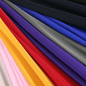 May include: A collection of fabric swatches in various colors, including pink, yellow, red, purple, gray, blue, and black. The fabric is arranged in a fan shape, with the lightest colors at the bottom and the darkest colors at the top.