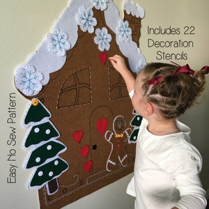 May include: A felt gingerbread house with a white roof and a gingerbread man on the door. The house is decorated with felt snowflakes, hearts, and a Christmas tree. The text "Includes 22 Decoration Stencils" is visible in the image.