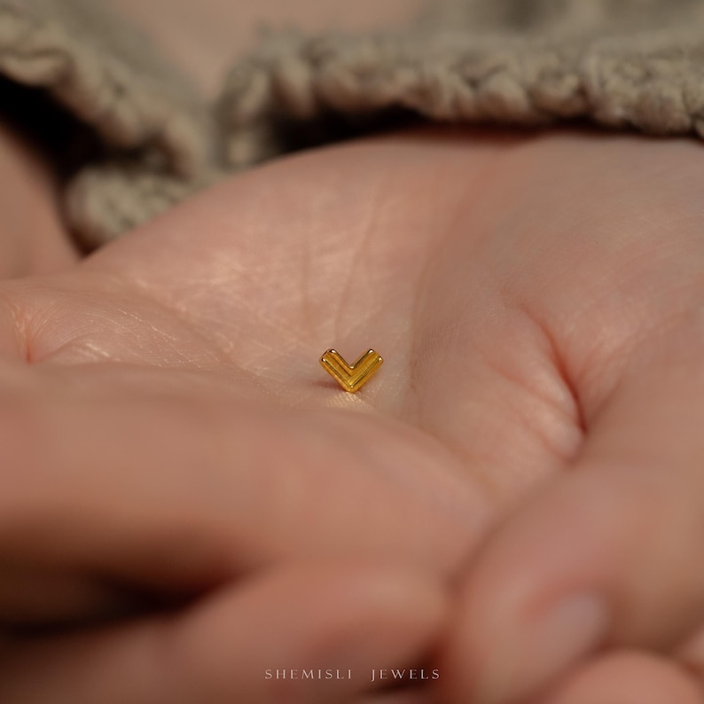 a baby's hand with a tiny yellow object in it's palm