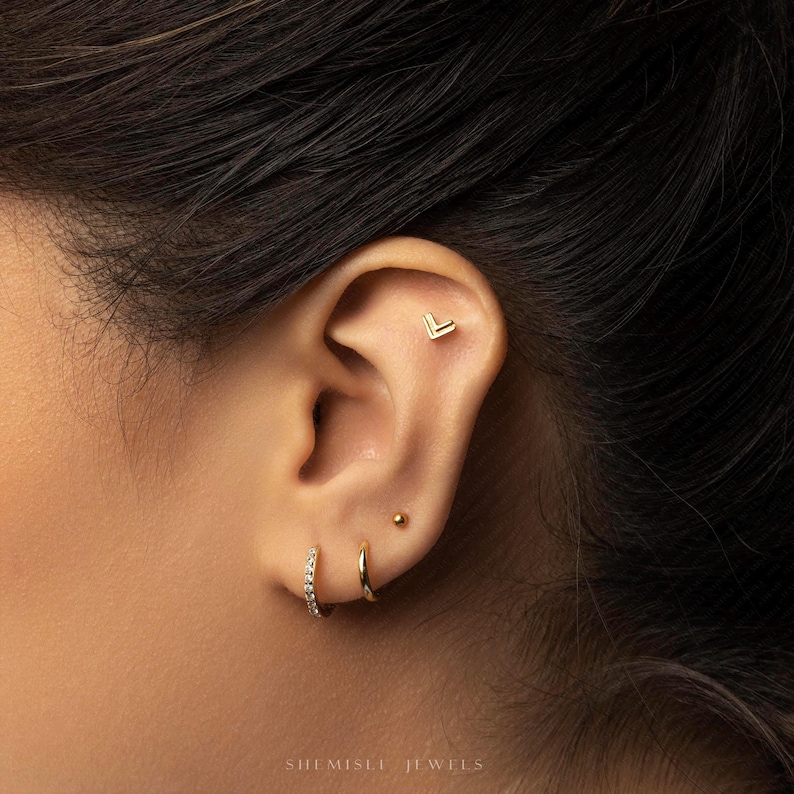 a close up of a person wearing a pair of ear piercings