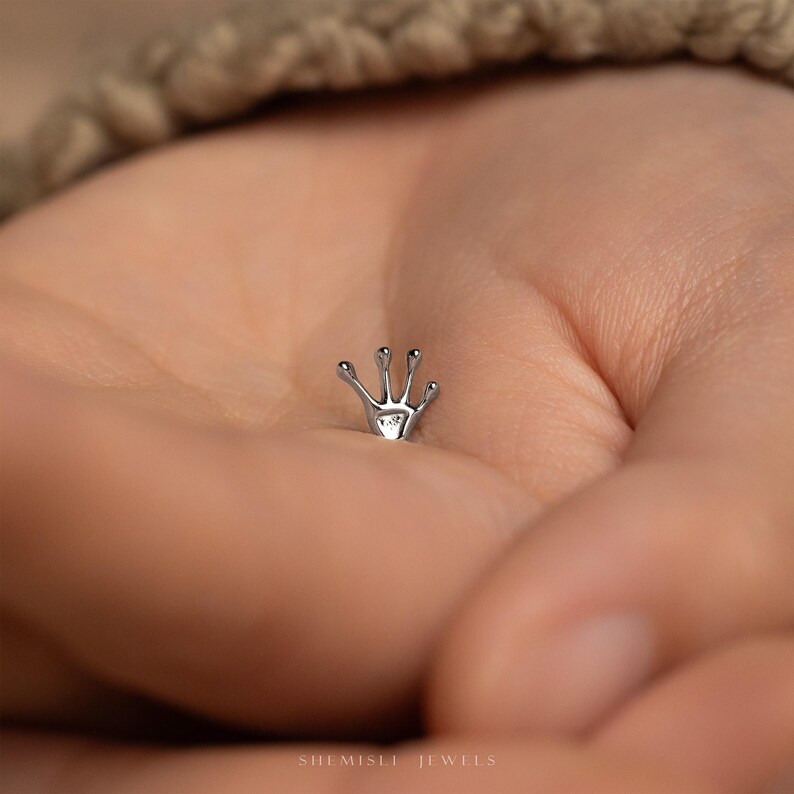 a tiny ring with a tiny hand on it