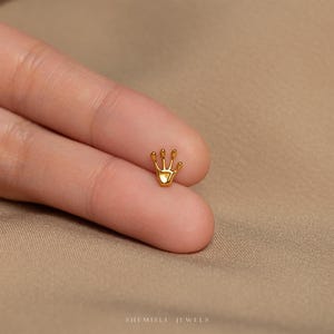 a person wearing a gold ring with a crown on it