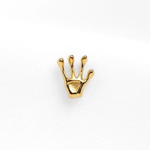 a gold brooch with a crown on top of it
