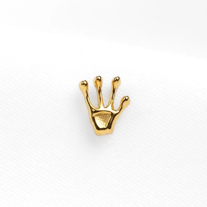 a gold brooch with a crown on top of it