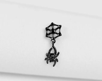 May include: A black earring with a spider web design and a dangling spider charm. The spider has eight legs and a detailed body. The earring is set against a white background. The design is gothic-inspired.