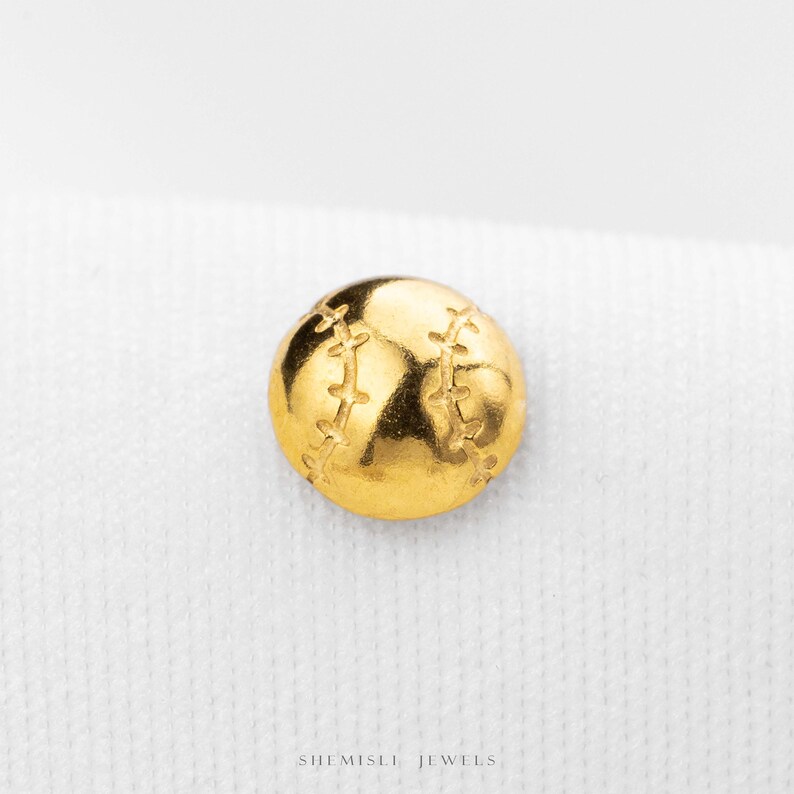 A gold-colored baseball pin is centered on a white background.