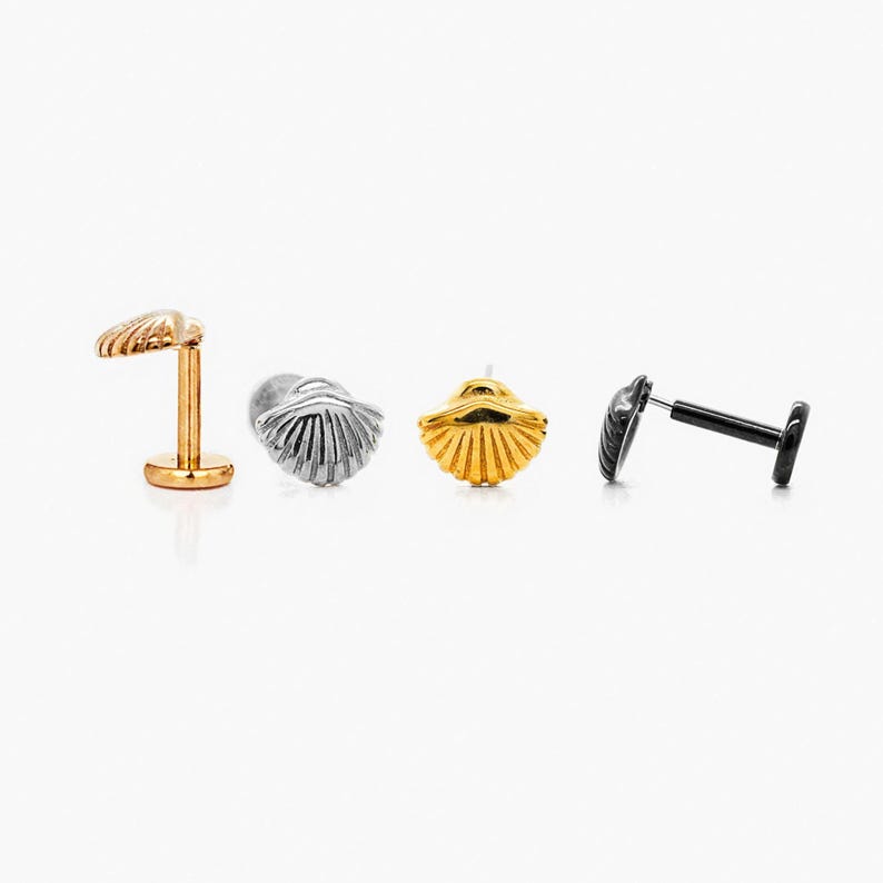 four different types of earrings, including a gold earring, a silver earring, a black earring, and a gold earring.