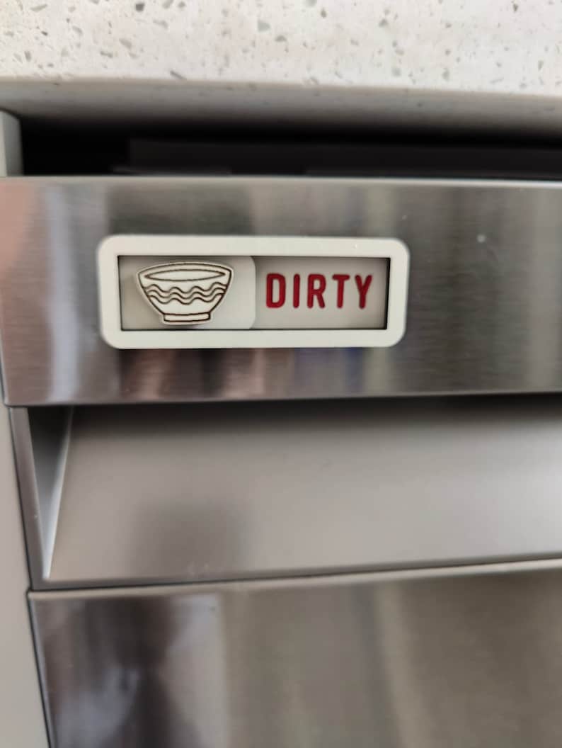 May include: A white magnetic sign with a red "DIRTY" label and a black and white icon of a bowl, indicating a dishwasher is dirty.
