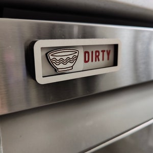 May include: A white wooden sign with the word "DIRTY" in red letters and a black and white illustration of a bowl. The sign is attached to a stainless steel appliance.