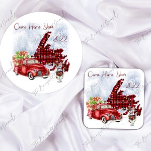 Puede incluir: Una camioneta roja con un árbol de Navidad en la parte trasera conduce por un paisaje nevado. La camioneta conduce por el contorno de la provincia de Terranova, Canadá. El texto "Come Home Year 2022" está escrito en la imagen.