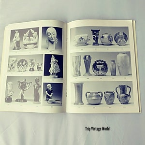 May include: A book showcasing a collection of vintage ceramic and porcelain figurines and vases. The book features black and white photographs of various items, including a woman's head, a dancing figure, and a variety of vases.