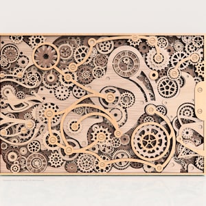 May include: Wooden wall art featuring a complex arrangement of gears, cogs, and mechanical components. The artwork is framed in a light wood, with intricate details and varying sizes of gears. The design evokes a steampunk aesthetic.