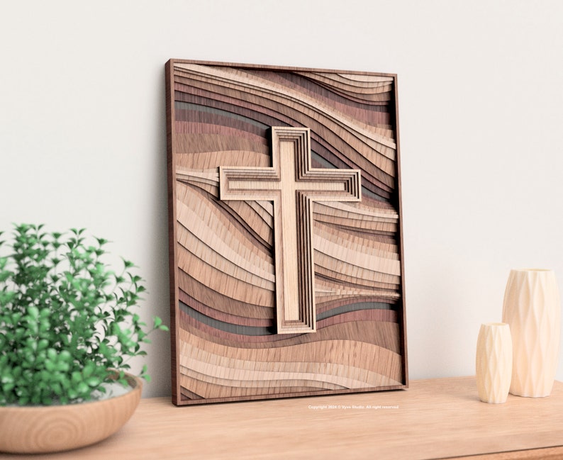 Puede incluir: Una pieza de arte mural de madera en capas con un dise&ntilde;o de cruz. La obra de arte presenta una cruz en el centro, con un fondo de madera en capas en varios tonos de marr&oacute;n y beige. Est&aacute; enmarcada con un borde marr&oacute;n oscuro.