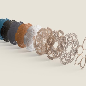 May include: A series of laser-cut mandala designs in shades of blue, black, orange, white, and gold. The detailed patterns are arranged in a row, demonstrating the intricate craftsmanship and artistic style. Measurements are in centimetres.