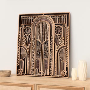 May include: A layered wooden wall art piece with an Art Deco design. The artwork features intricate cutouts of arches, geometric shapes, and floral patterns in shades of brown and tan. It is displayed on a wooden cabinet.