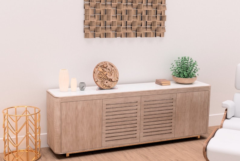 May include: A wooden cabinet with a white countertop holds decorative items, including vases, a small gray cup, and a wooden clock mechanism. A gold geometric side table and a wooden wall art piece are also visible.