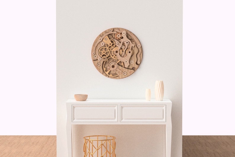 May include: A round, wooden wall art piece featuring a layered design of gears and mechanical components. The artwork is in shades of brown and beige, creating a three-dimensional effect. It hangs on a white wall above a white console table.