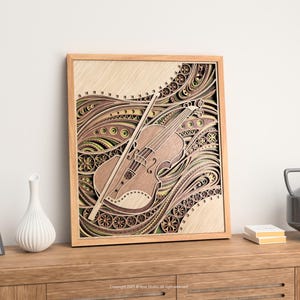 May include: A wooden framed, layered art piece featuring a violin and bow. The artwork has a light brown color with intricate patterns and designs in shades of brown, green, and yellow. The violin is positioned diagonally across the frame.