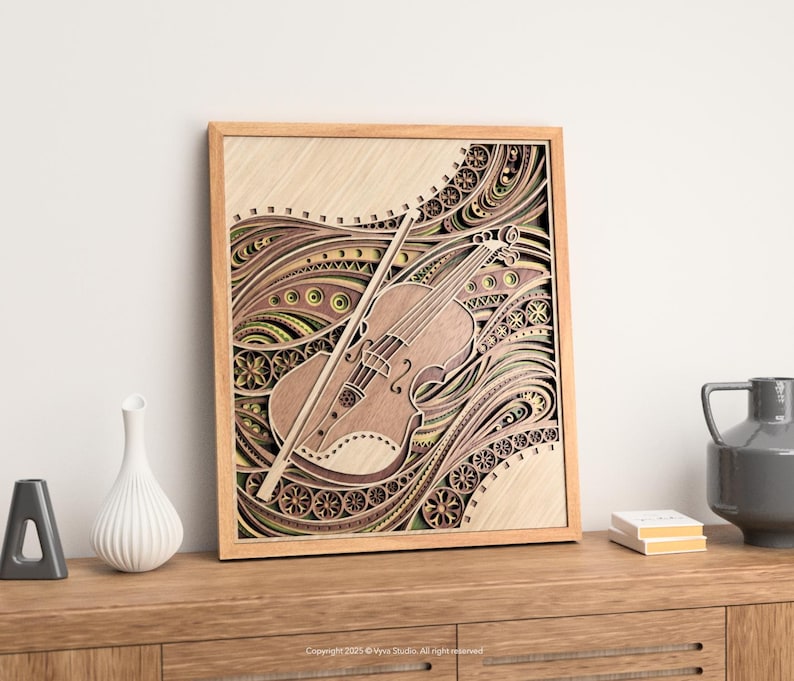 May include: A wooden framed, layered art piece featuring a violin and bow. The artwork has a light brown color with intricate patterns and designs in shades of brown, green, and yellow. The violin is positioned diagonally across the frame.