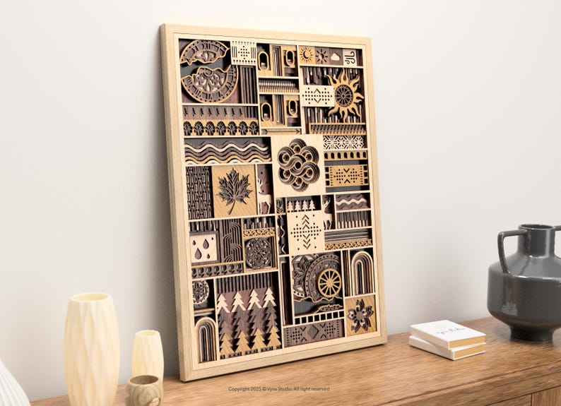 May include: A wooden wall art piece with a light wood frame. The artwork features a layered design with various shapes and patterns, including a sun, maple leaf, and trees. The artwork is displayed on a wooden surface.